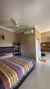 - une chambre avec un lit et un ventilateur de plafond dans l'établissement Cenang Room Rahsia Motel, à Pantai Cenang