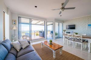 sala de estar con sofá azul y mesa en Port Willunga Ocean Views Beachhouse, en Port Willunga