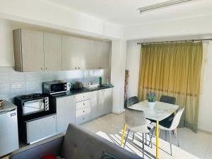 uma cozinha com um sofá e uma mesa num quarto em Angela Holiday Apartments em Pafos