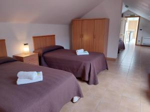 Cette chambre d'hôtel comprend 2 lits avec des draps violets. dans l'établissement Hospedería Externa del Monasterio, à Samos
