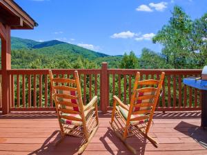 two chairs sitting on a deck with a view of mountains at A Majestic View III in Townsend