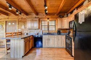 a kitchen with wooden cabinets and a black refrigerator at A Majestic View III in Townsend +51 photos