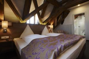 una camera con un grande letto in una stanza con soffitti in legno di Boutique Hotel zur Post a Vohburg an der Donau