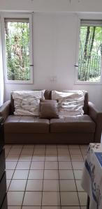 a couch in a living room with two windows at AUTEUIL PASSY in Paris