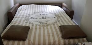 a bed with two pillows on top of it at AUTEUIL PASSY in Paris