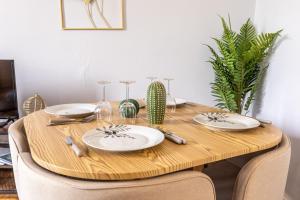 - une table en bois avec des assiettes et des verres à vin dans l'établissement F3 Av république avec garage (c), à Clermont-Ferrand