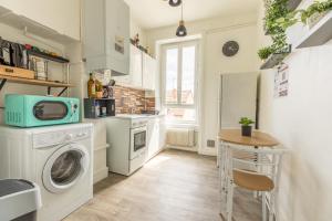 uma cozinha com uma máquina de lavar roupa e uma mesa em F3 Av république avec garage (c) em Clermont-Ferrand