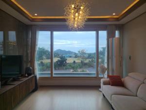 a living room with a large window and a couch at Daejeong Prabang in Seogwipo