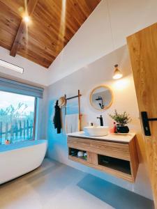 a bathroom with a tub and a sink and a bath tub at Palme villa - Venuestay 