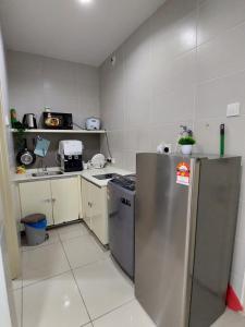 a kitchen with a stainless steel refrigerator and a stove at 3 Elements-MRT2 -30min to TRX Bkt Bintang -Wifi - Self Check In in Seri Kembangan