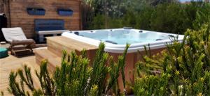 a jacuzzi tub in a yard with plants at Blacksheep Sagres Guesthouse & Surf in Sagres