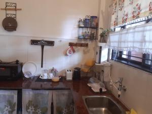 een keuken met een wastafel en een aanrecht bij Cornwall for Couple in Madikeri