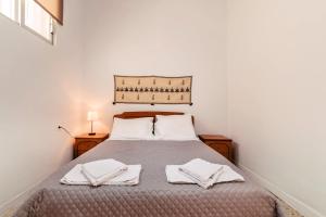 1 dormitorio con 1 cama con 2 toallas en Olympia's Cozy Guesthouse, en Psinthos