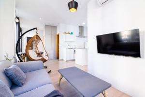 un soggiorno con divano e TV a parete di Precioso Apartamento en el Centro de Granada. a Granada