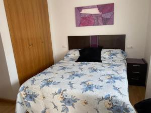 um quarto com uma cama com um edredão floral azul em Sensacional piso en San Fernando em San Fernando