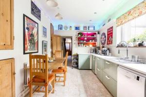 a kitchen with a table and some chairs in it at Tŷ Selah, Rugby Ave, Neath in Neath