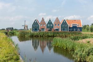 una fila de casas coloridas junto a un río en Marinapark Volendam, en Volendam