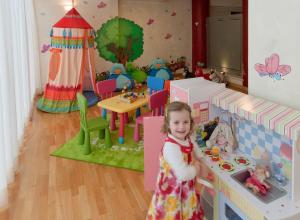 a little girl is standing in a play room at Hotel Montecarlo in Bibione