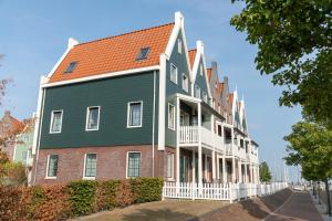 una casa grande con techo naranja en una calle en Marinapark Volendam, en Volendam