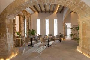 an archway in a room with tables and chairs at Petit Palau Alcudia - Adults Only in Alcudia