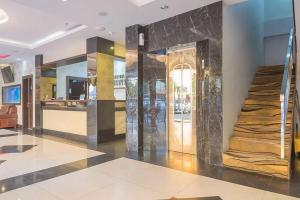 a lobby with a door with a marble wall at RedDoorz Premium near Grand Batam Mall in Nagoya