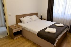 1 dormitorio con 1 cama con 2 toallas en Pensiunea Happy Day Horezu en Horezu