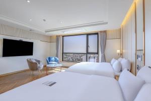 a hotel room with a large bed and a large window at H avenue Kijang Ilgwang in Busan