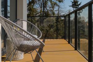 a wooden deck with two chairs on it at Wellness Resort & SPA Apartments Dziwnów Riverfront by Renters in Dziwnów