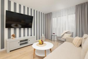 Μια τηλεόραση ή/και κέντρο ψυχαγωγίας στο Wellness Resort Apartments Dziwnów Riverfront by Noclegi Renters +182 φωτογραφίες