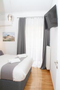 um quarto com 2 camas e uma televisão de ecrã plano em Acropolis Luxurious Legacy em Atenas
