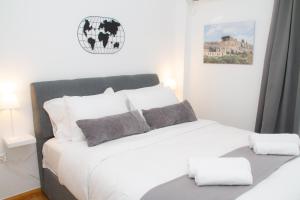 una camera da letto con un letto bianco con cuscini bianchi di Acropolis Luxurious Legacy ad Atene