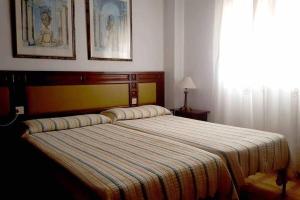 een slaapkamer met een groot bed en een gestreepte deken bij Casa Aguacate in Taramay