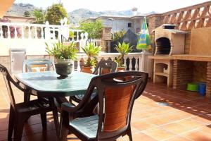 een patio met een tafel en stoelen en een pizza-oven bij Casa Aguacate in Taramay