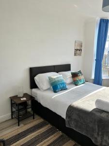 een slaapkamer met 2 bedden, blauwe gordijnen en een tafel bij Keepers Rest Scarborough North Bay in Scarborough