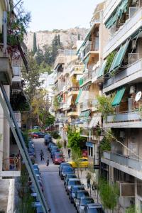 uma rua da cidade com carros estacionados e edifícios em Acropolis Luxurious Legacy em Atenas