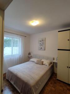 Un dormitorio con una cama grande y una ventana en Apartment Angelina, en Dubrovnik