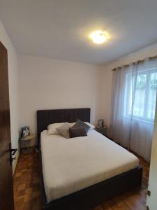 1 dormitorio con 1 cama con sábanas blancas y ventana en Apartment Angelina, en Dubrovnik