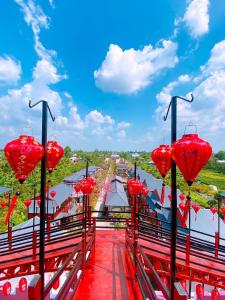 un gruppo di lanterne rosse in cima a un ponte di Homestay Pink House (Ngôi nhà màu hồng) a Ấp Ðông Qứi