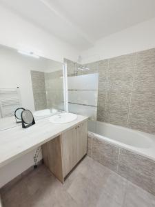 a bathroom with a sink and a bath tub at Escapade Ensoleillée in Mimizan +19 photos