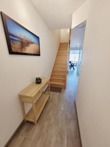 a room with a staircase with a desk and a television at Escapade Ensoleillée in Mimizan