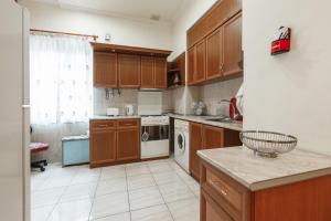a kitchen with wooden cabinets and a counter top at Large apartment by the Opera- luxury living room, 2 bedrooms, equipped kitchen and balcony in Yerevan +8 photos