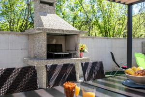 a stone pizza oven on a patio with a table at Villa Veroniq in Županje +26 photos