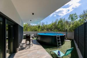a backyard with a hot tub and chairs at Villa Veroniq in Županje