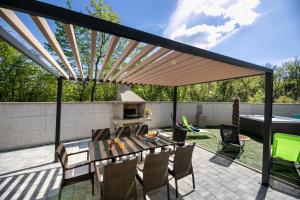 a pergola on a patio with a table and chairs at Villa Veroniq in Županje