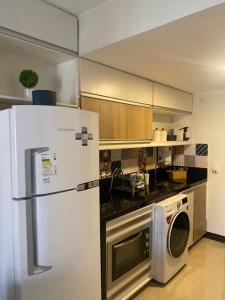 a kitchen with a refrigerator and a microwave at Flat Lake Side Linda Vista Lago c/banheira in Brasília