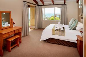 a bedroom with a large bed and a window at First Group Chaka's Rock Chalets in Ballito