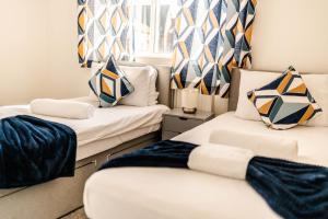 um quarto com duas camas com almofadas em Urban Oasis l 3-Bed Gem in Watford Town Center em Watford