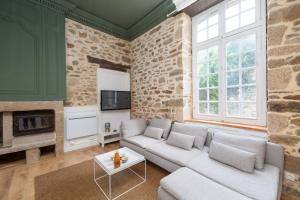 sala de estar con sofá y chimenea en Superbe appartement avec jardin Dinan centre - Jerzual, en Dinan