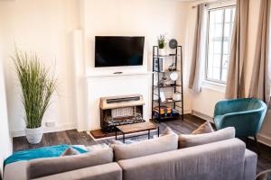 a living room with a couch and a fireplace at Urban Oasis l 3-Bed Gem in Watford Town Center in Watford