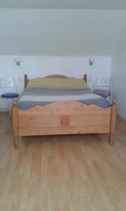 1 dormitorio con cama de madera en una habitación en Le Bon Accueil, en Antrain